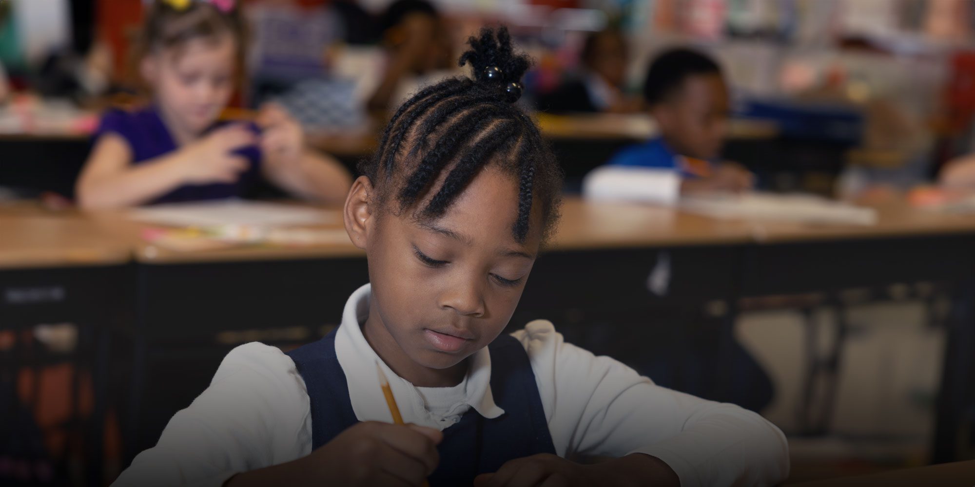 Student writing at desk